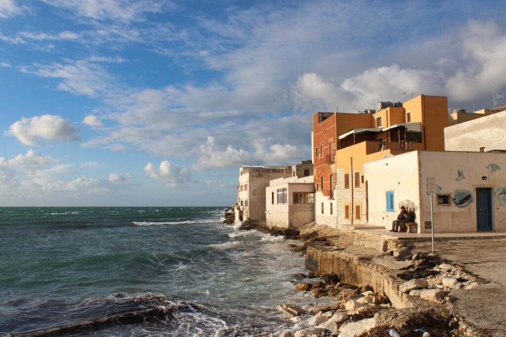 Trapani im Winter: Zwei Männer geniessen auf einer Bank die Sonne